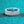 Silver ring with clear gemstones on a teal glittery background