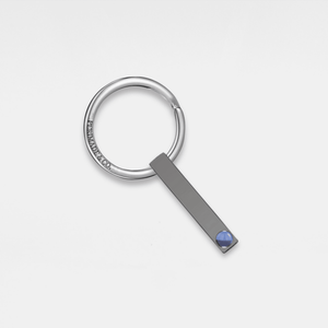 A silver keychain with a gold-plated accent and a small crystal embellishment.