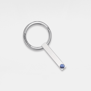 A silver keychain with a gold-plated accent and a small crystal embellishment.