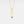 Gold necklace with a vertical bar pendant on a light gray background