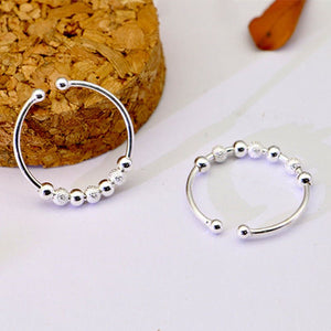 Silver nose ring with beads on a textured surface