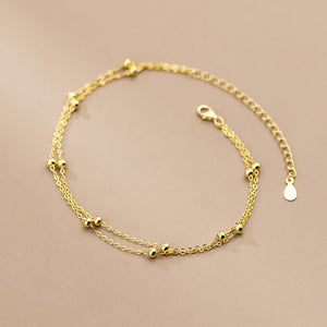 Gold bracelet on a beige background