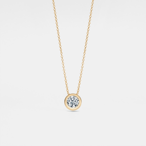 A small round moissanite pendant necklace with a gold chain and a gold setting.