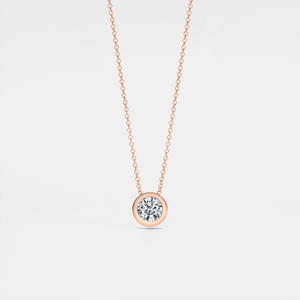 A small round moissanite pendant necklace with a gold chain and a gold setting.