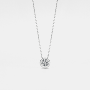 A small round moissanite pendant necklace with a gold chain and a gold setting.