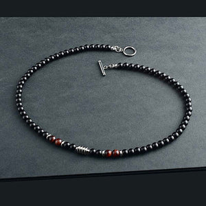 Three black agate crystal bead necklaces with varying details, displayed on a grey surface. One necklace features gold plating, another has a smooth finish, and the third includes metallic bead accents.