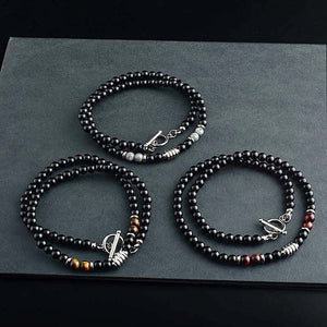 Three beaded necklaces with silver clasp on a dark surface