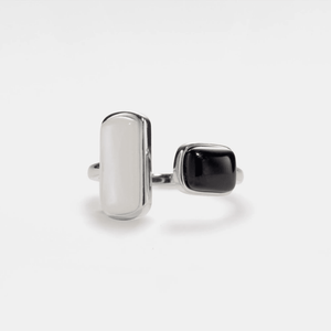 A cocktail ring with a gold plating, featuring a white and a black agate cabochon, set transversely.