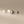 Four star-shaped earrings on a beige background