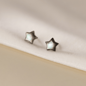 Star-shaped earrings on a beige background