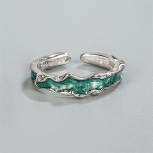 A pair of silver rings with green accents, designed to be adjustable and fit US sizes. The rings have a textured finish and are presented against a light background.