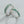 Silver toe rings with green gemstone inlay on a light gray background