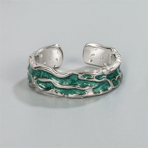 A pair of silver rings with green accents, designed to be adjustable and fit US sizes. The rings have a textured finish and are presented against a light background.