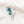 Silver brooch with blue gemstones on a light background