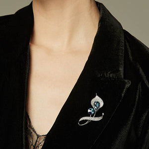 Black jacket with a decorative brooch featuring blue gemstones on a neutral background