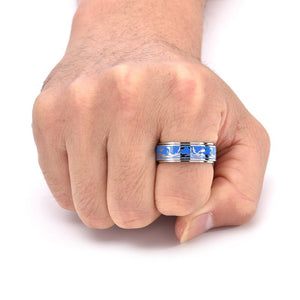 Hand wearing a ring with blue and silver design on a white background