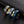 Three rings with blue and gold design on a dark textured surface
