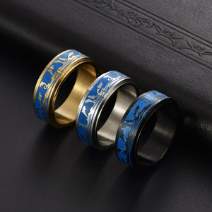 Three rings with blue and gold design on a dark textured surface