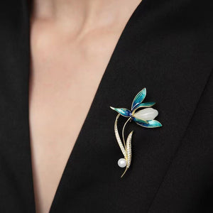 Floral brooch with blue and white design on a black blazer