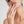 Close-up of a woman's hand with a evil eye spinner ring on her finger, touching her lips against a neutral background