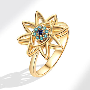 Gold evil eye flower spinner ring with a blue gemstone on a white background