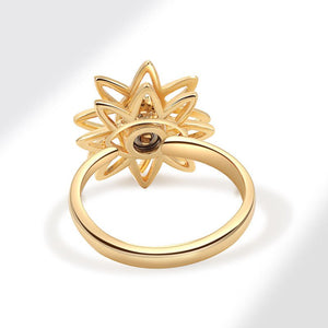 Gold evil eye flower spinner ring with a blue gemstone on a white background