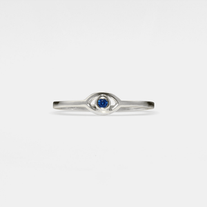 Silver evil eye ring with a blue gemstone on a light gray background