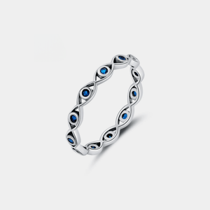 Silver evil eye ring with blue gemstones on a light gray background