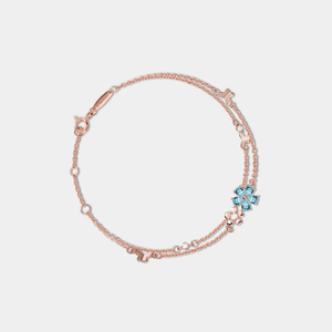 Rose gold bracelet with blue gemstones on a light gray background