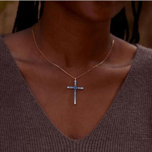 Necklace with a cross pendant worn by a person