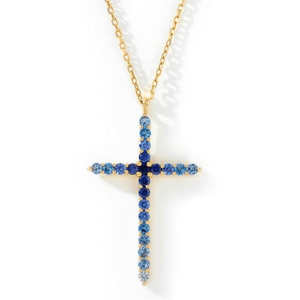 Gold cross necklace with blue stones on a white background