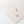 Gold necklace with leaf-shaped pendants on a light background