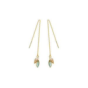 Gold leaf-shaped earrings on thin chains against a white background