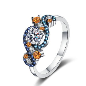 Silver ring with orange and blue gemstones on a white background