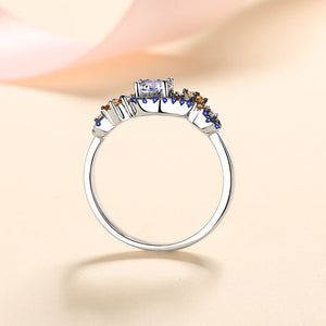 Silver ring with colorful gemstones on a beige background