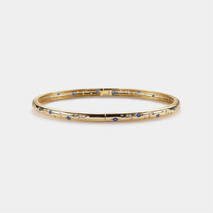 Gold bracelet with blue stones on a white background