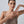 Woman pointing to her armpit on a plain background