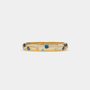 A gold-plated sterling silver band ring with blue and white cubic zirconia set in a pattern resembling moon and stars.