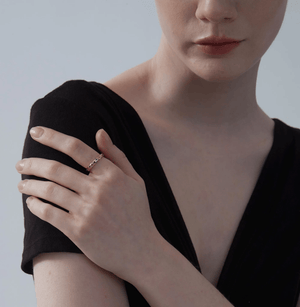Close up model wearing a gold moon and star ring with blue and clear gemstones