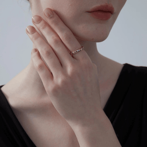 Close up model wearing a gold moon and star ring with blue and clear gemstones