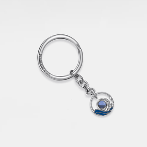 Silver projection keychain with a blue wave pendant on a white background
