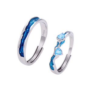 Two silver rings with blue gemstones on a white background