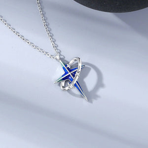 A couple of silver necklaces with blue star-shaped pendants and gold plating, displayed on a reflective surface.
