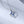 A couple of silver necklaces with blue star-shaped pendants and gold plating, displayed on a reflective surface.
