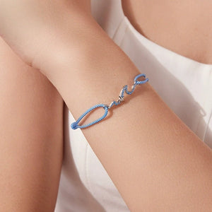 Blue bracelet on a person's wrist with a white background