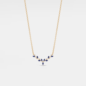 Gold necklace with blue gemstones on a light gray background