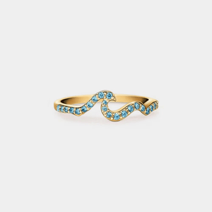 Gold ring with blue gemstones on a light gray background