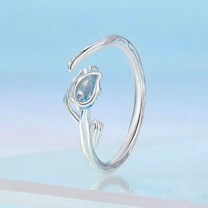 Silver ring with a blue gemstone on a light blue background