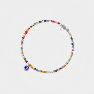 Colorful beaded bracelet with a blue evil eye charm on a light gray background