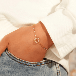 Close-up of a person wearing a gold bracelet on a white background